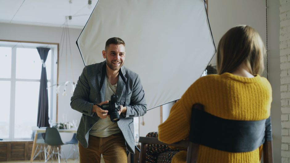 Photographer capturing a portrait session in a modern studio setting.
