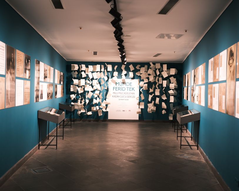 Contemporary art gallery featuring floating paper installation and informative portraits.