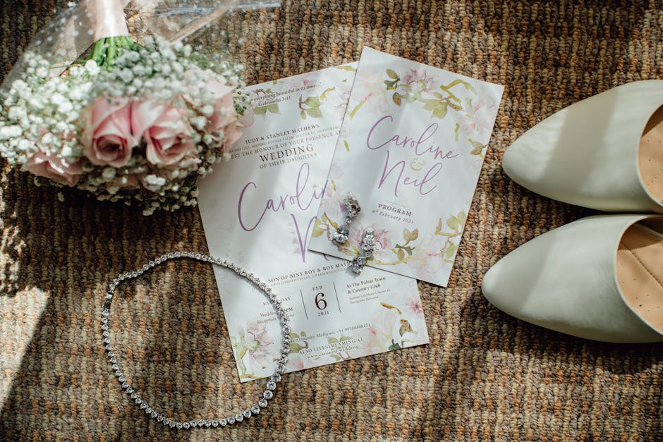 Elegant wedding flat lay featuring invitations, flowers, shoes, and jewelry on a textured surface.